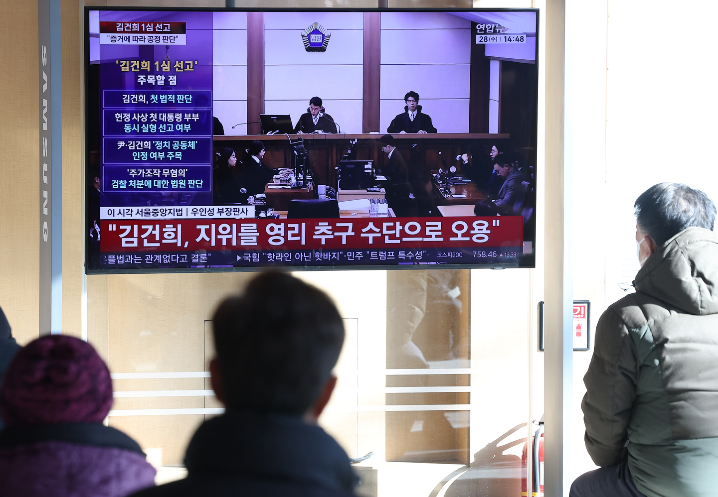 Commuters watch news coverage of Kim Keon Hee’s verdict at Seoul Station in central Seoul on Jan. 28. [YONHAP] 