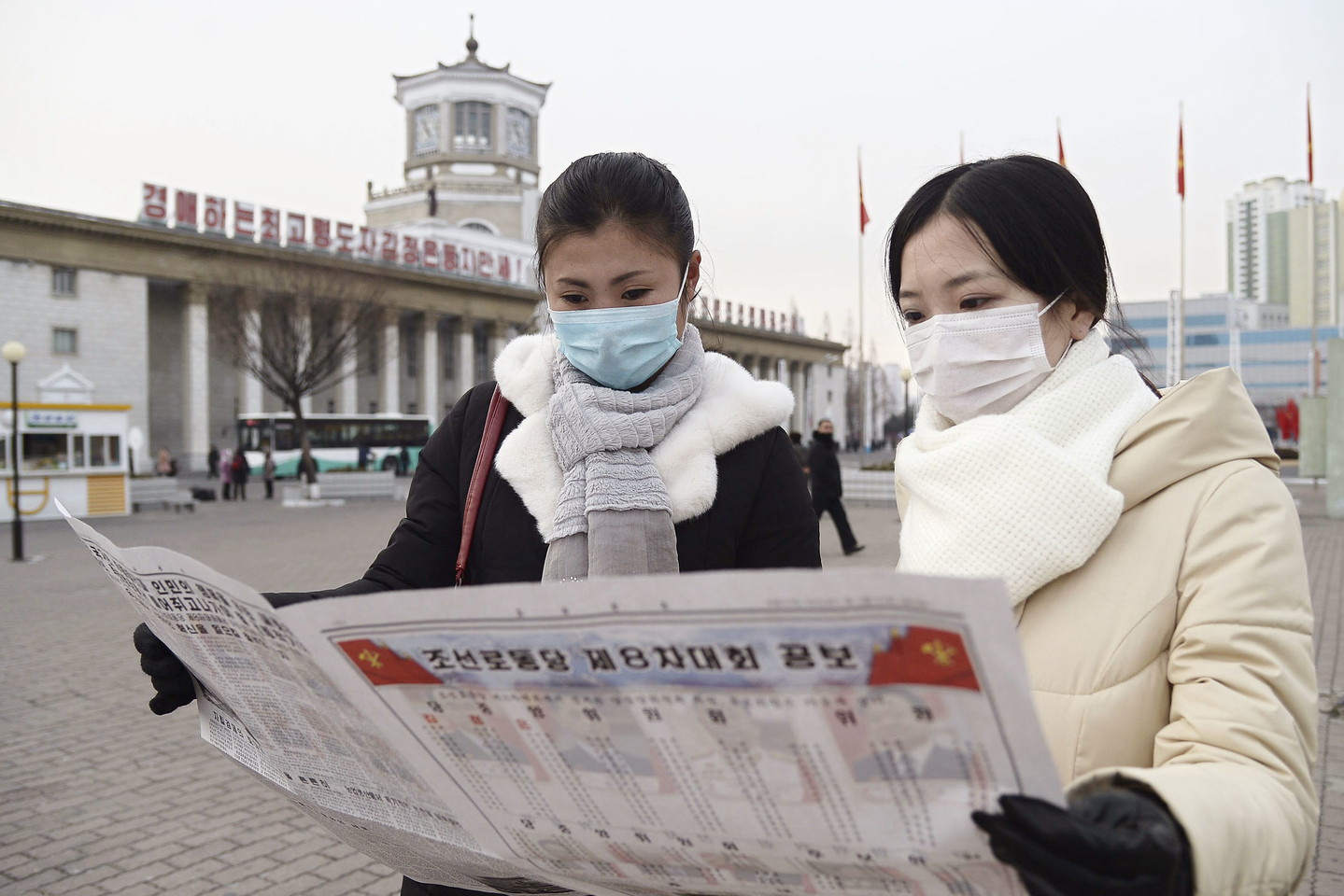 North Korean citizens read newspaper in Pyongyang on Jan. 11, 2021, carrying the news of the ruling Workers' Party of Korea holding the 8th party congress. The official Korean Central News Agency said the same day that the congress endorsed North Korean leader Kim Jong-un's election as general secretary of the Workers' Party, taking over the top post from his late father. [KYODO/YONHAP]