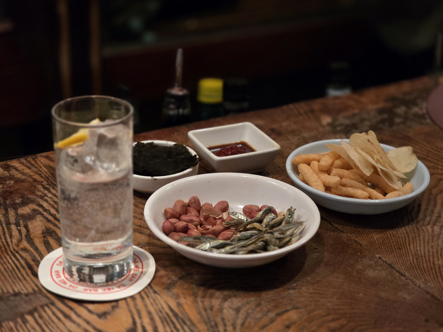 Dahee's signature gin tonic served with basic snacks such as gim (seaweed), dried anchovies, peanuts and chips. [JIN EUN-SOO]