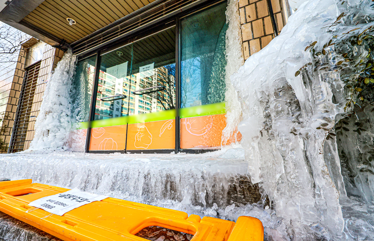 A burst water pipe blocks the entrance of a building after the water froze in Incheon’s Gyeyang District on Jan. 28, as temperatures dropped below minus 10 degrees Celsius (14 degrees Fahrenheit). [NEWS1]