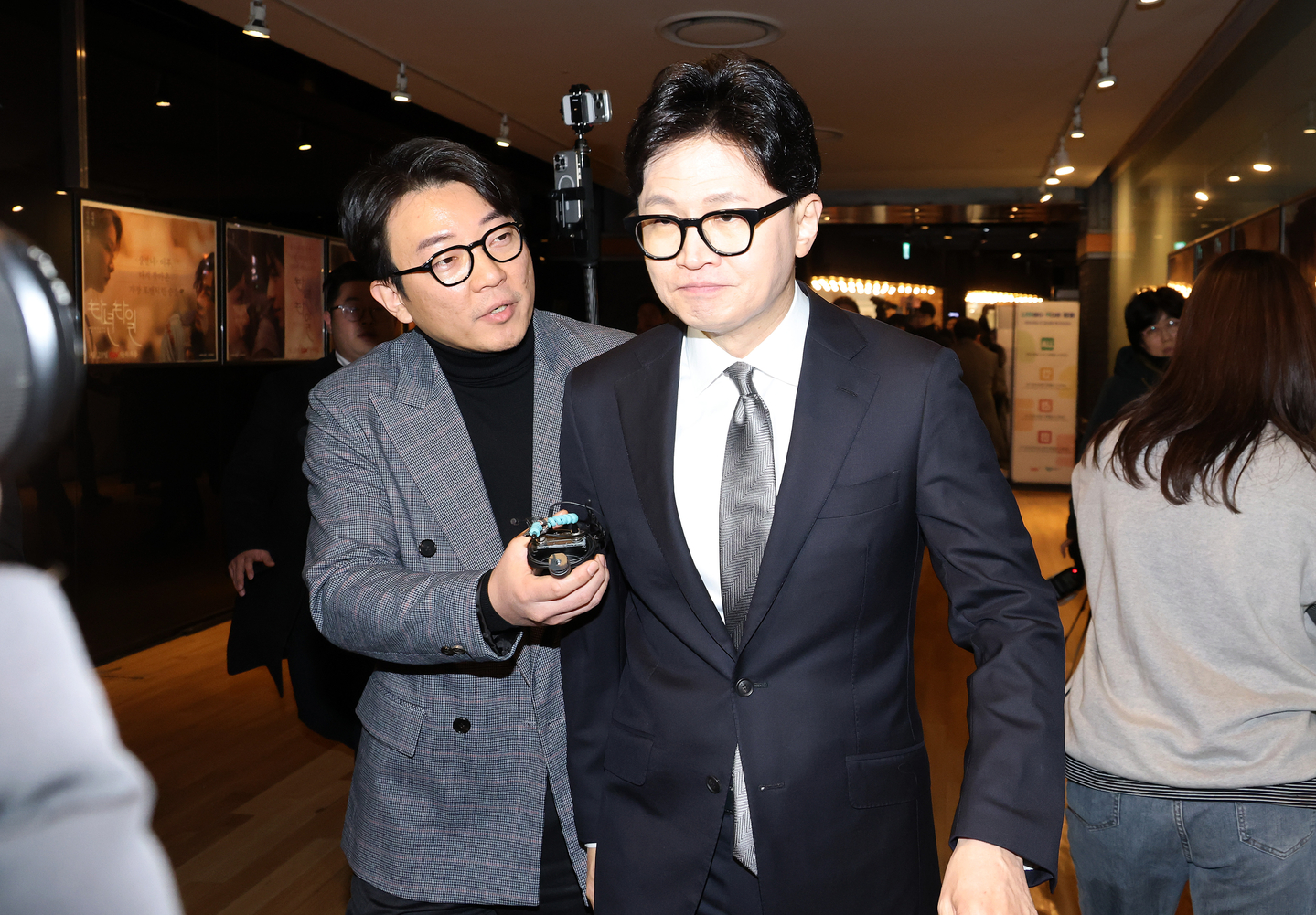 Han Dong-hoon, center, former leader of the People Power Party, ignores a reporter's question during his visit to a movie theater in western Seoul on Jan. 28.  [YONHAP] 