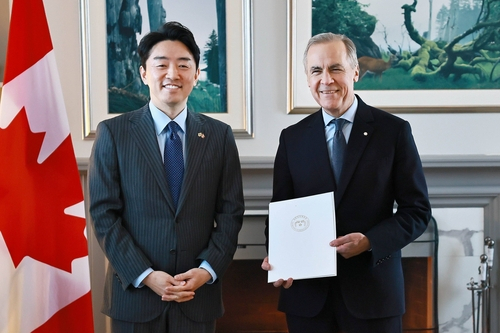 Kang Hoon-sik, left, President Lee Jae Myung's chief of staff, and Canadian Prime Minister Mark Carney pose for a photo after Kang delivered Lee's personal letter to Carney, in this photo captured from Kang's Facebook account. [YONHAP] 