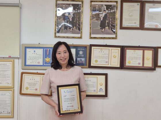 Lee Gyeong-suk poses for photos with her award certificate at the You and Me Happiness Center (translated) on Sept. 28, 2025. [JUN YUL] 