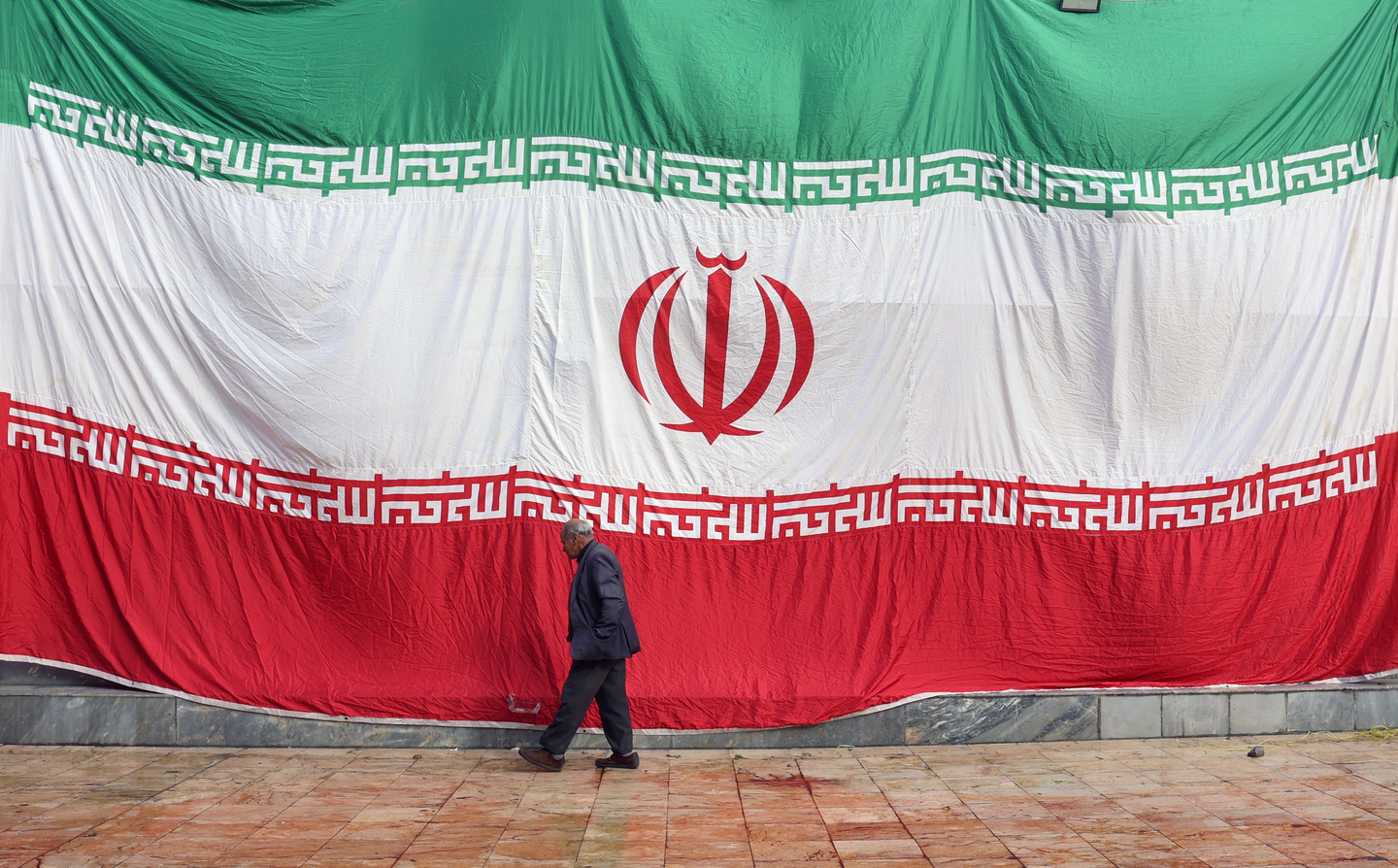 A huge Iranian national flag hangs from the wall of a mosque, which was damaged by fire during recent anti-government protests, in Tehran, Iran, on Jan. 21. [EPA/YONHAP] 