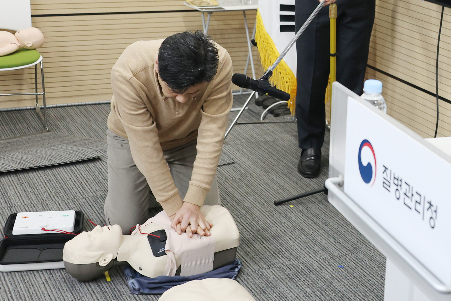 Lee Chang-hee, a professor of emergency medical services at Namseoul University, demonstrates how to attach automated external defibrillator pads without removing a woman’s undergarments, in line with the revised cardiopulmonary resuscitation guidelines, on Jan. 29. [YONHAP]