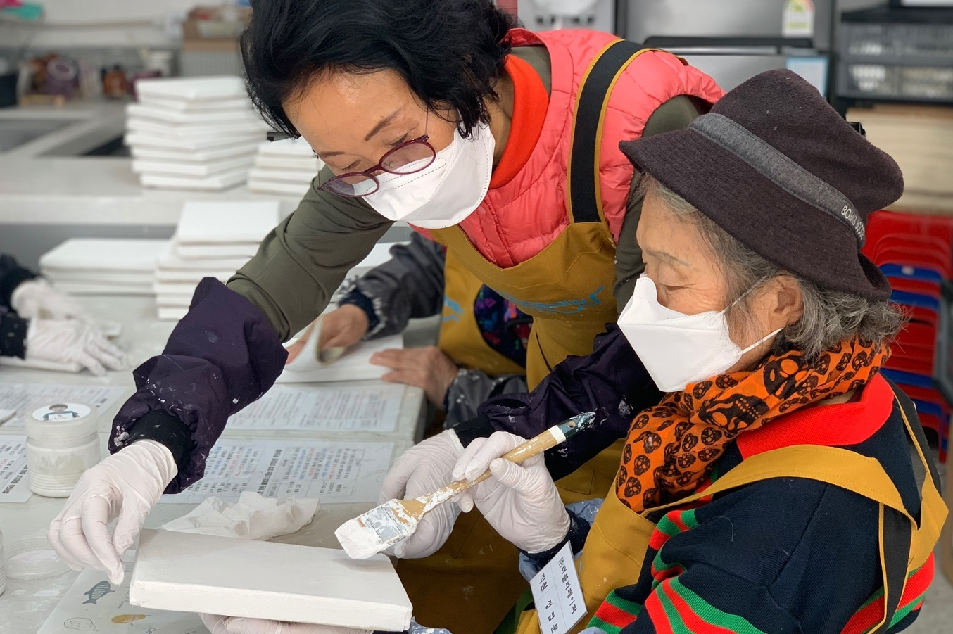 Artists hired by the nonprofit organization LoveRe: Paper paint on canvases made from discarded paper that has been collected. [LOVERE: PAPER]