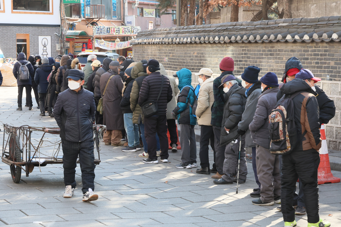 People wait in line for free meals at Tapgol Park in Nakwon-dong, Jongno District, central Seoul. [YONHAP]