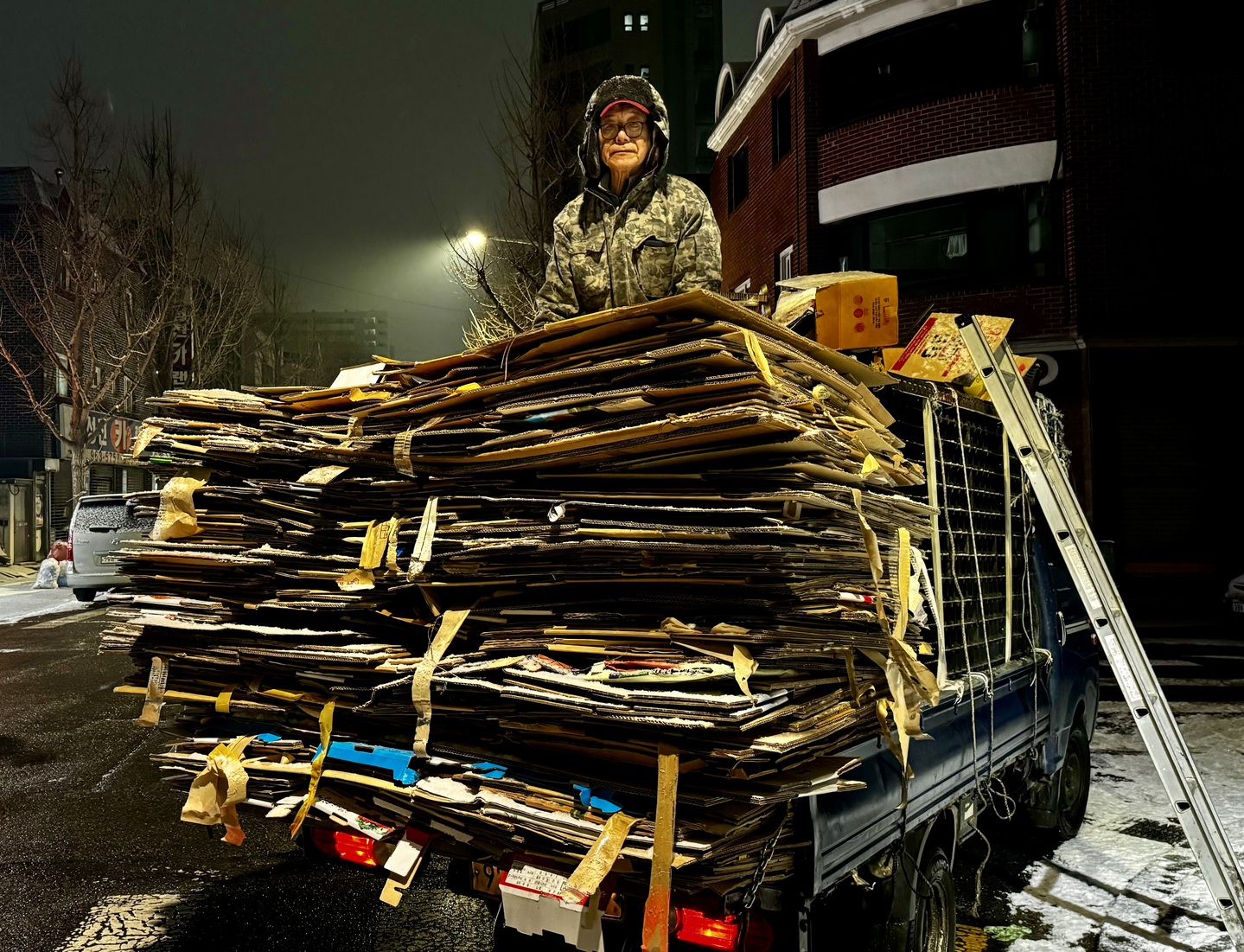 A man who collects paper and boxes poses for a photo. [JOONGANG ILBO]