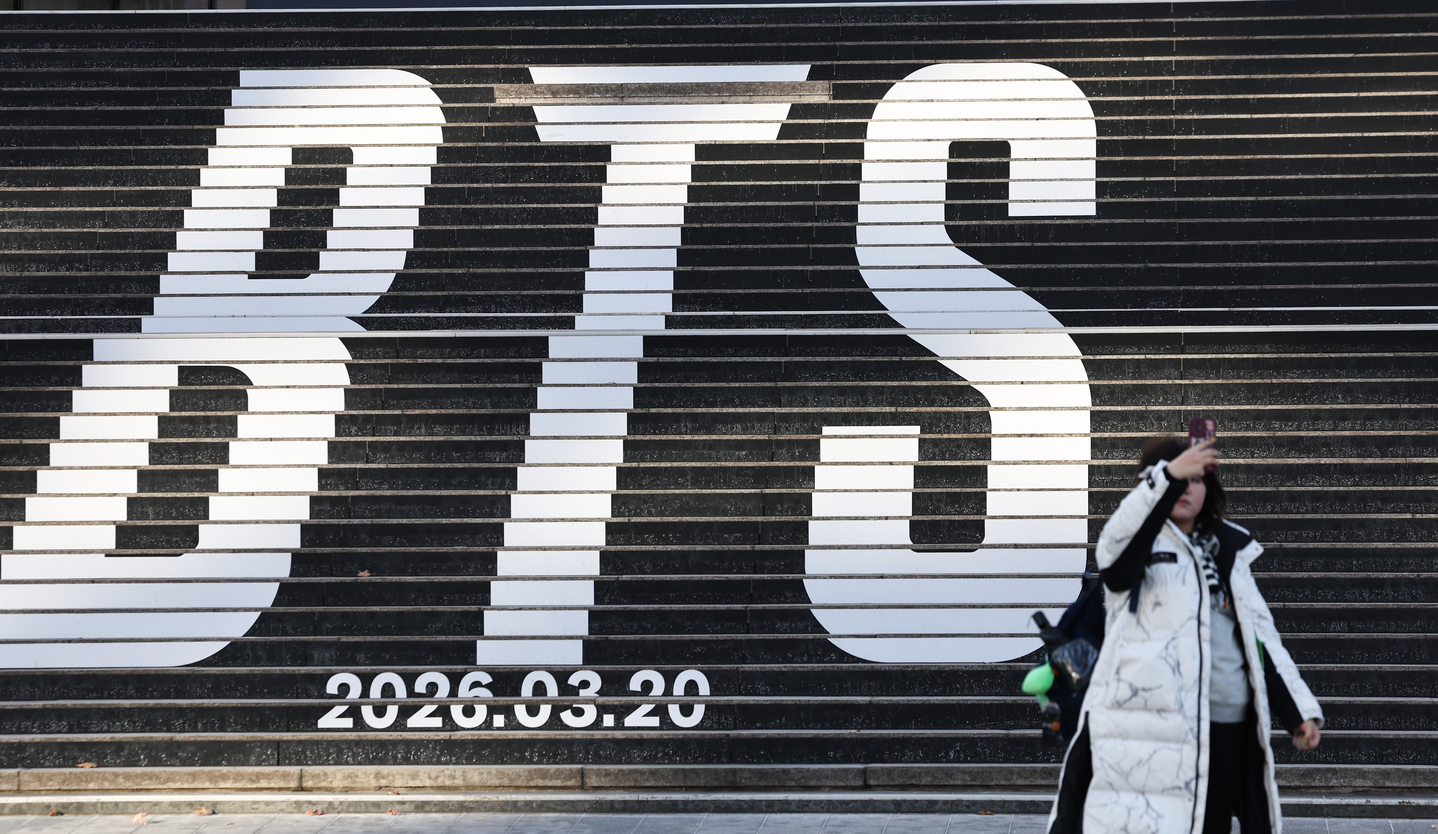 A tourist takes photos in front of a promotional display for BTS’s fifth full-length album, set up on the steps of Sejong Center for the Performing Arts in central Seoul on Jan. 22. [NEWS1]