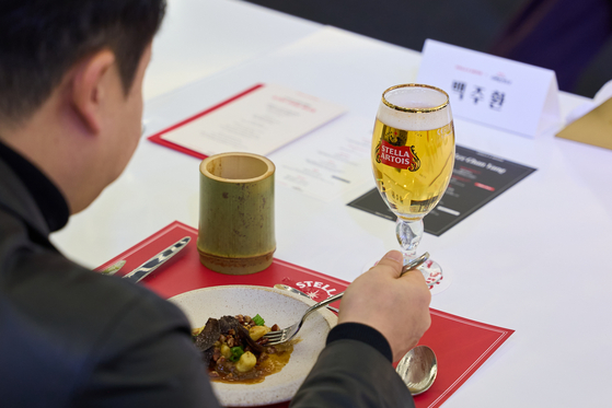A participant tries chef Lee Jun's cheese, oxtail and pecans and chef Lee Chan-yang's cavatelli and potato on Feb. 3 at the Stella Artois event in southern Seoul. [STELLA ARTOIS]