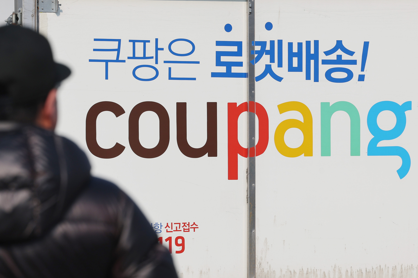 A person passes by a Coupang delivery truck at the company's logistics center in Seoul on Jan. 23. [YONHAP]