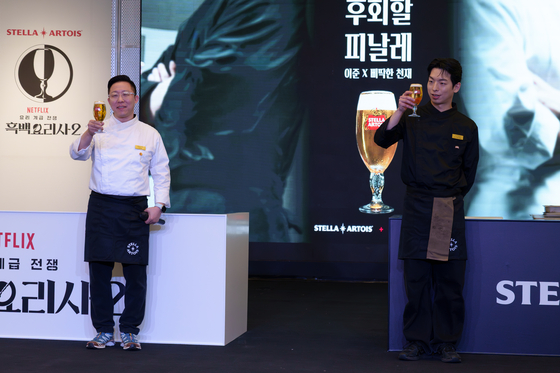 From left, Chefs Lee Jun and Lee Chan-yang, better known by his nickname “Rebellious Genius,” pose with a cup of Stella Artois lager on Feb. 3 at the Stella Artois event in southern Seoul. [CHO YONG-JUN]