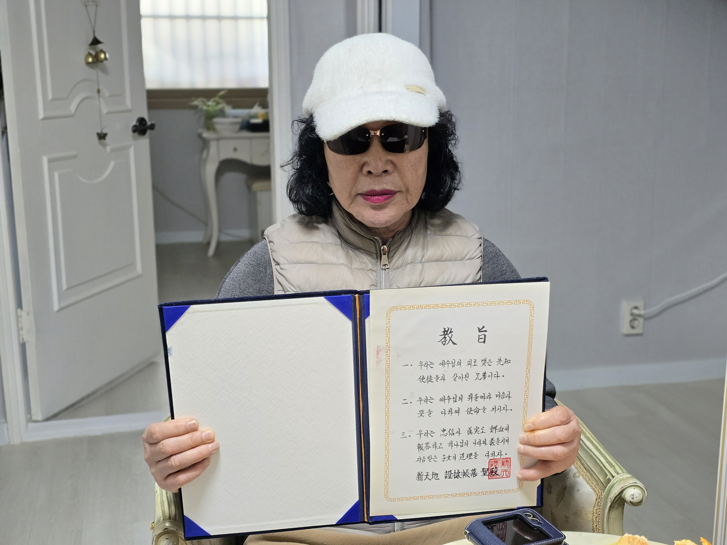 Kim Tae-soon, who joined Shincheonji in 1989 and left in 2020, holds up documents issued by the religious sect [SON SUNG-BAE]