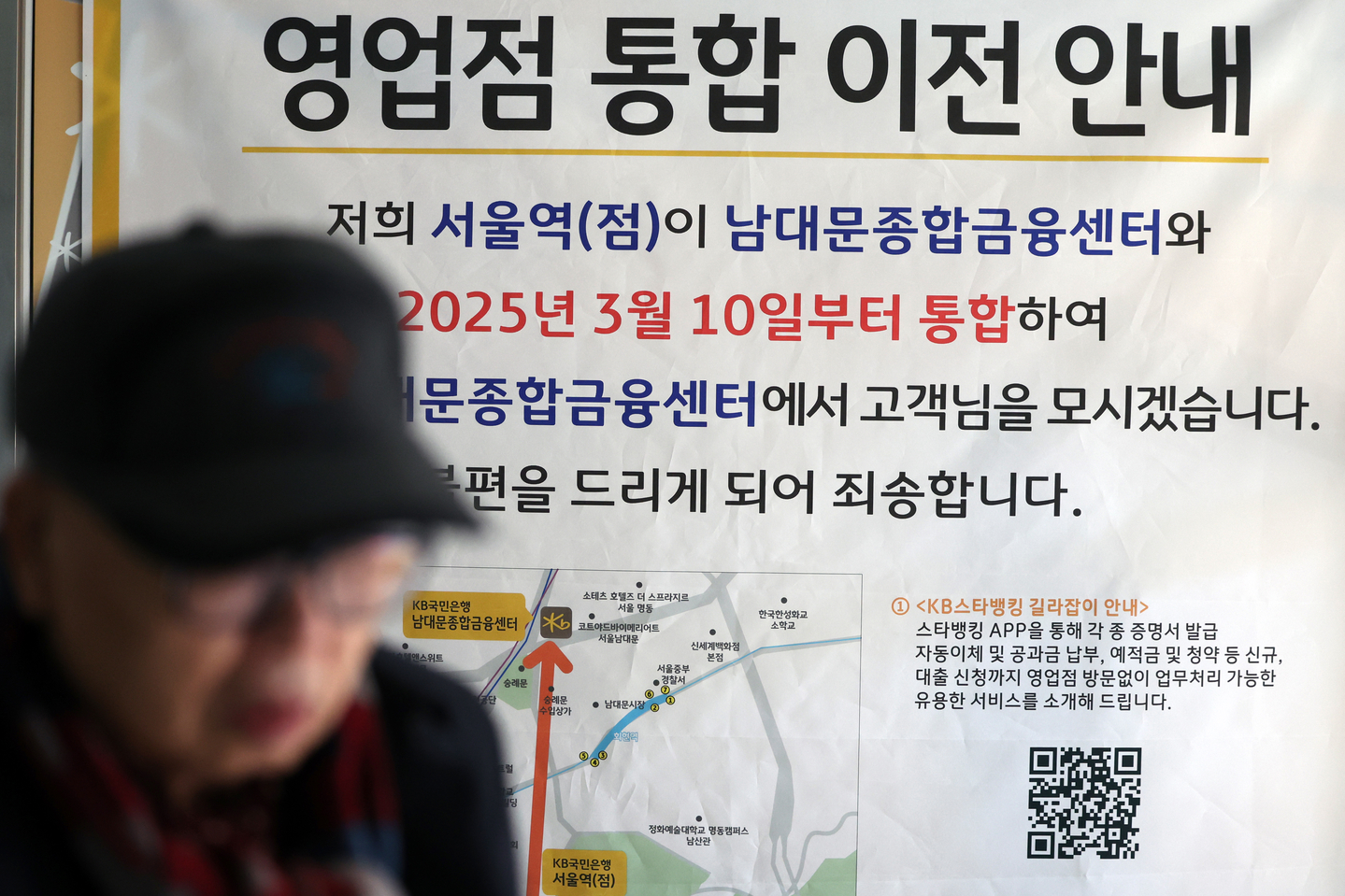 A notice announcing the merger of two KB Kookmin Bank branches is posted up on the entrance of a branch near Seoul Station in central Seoul on Feb. 11, 2025. [YONHAP] 