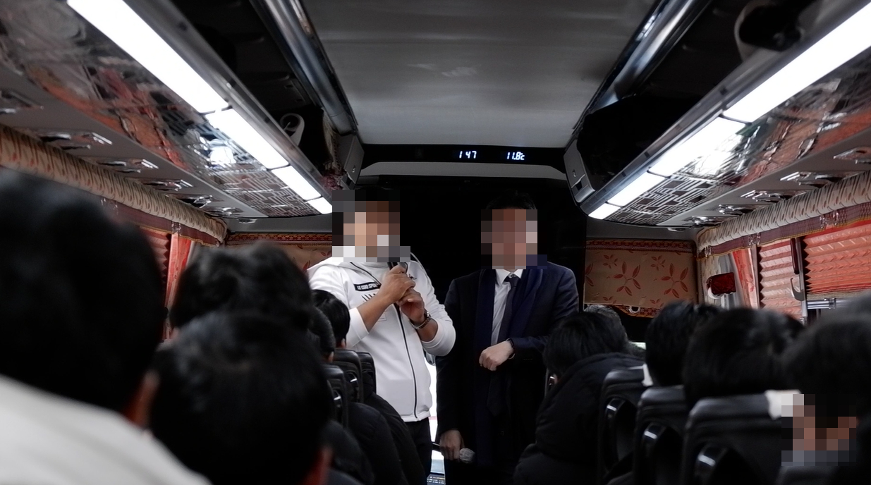 Uzbek students from Hanshin University in Osan, Gyeonggi, are briefed on reasons, including issues related to bank balance requirements, for their removal from the country while on a bus on Nov. 27, 2023. [JOONGANG ILBO]