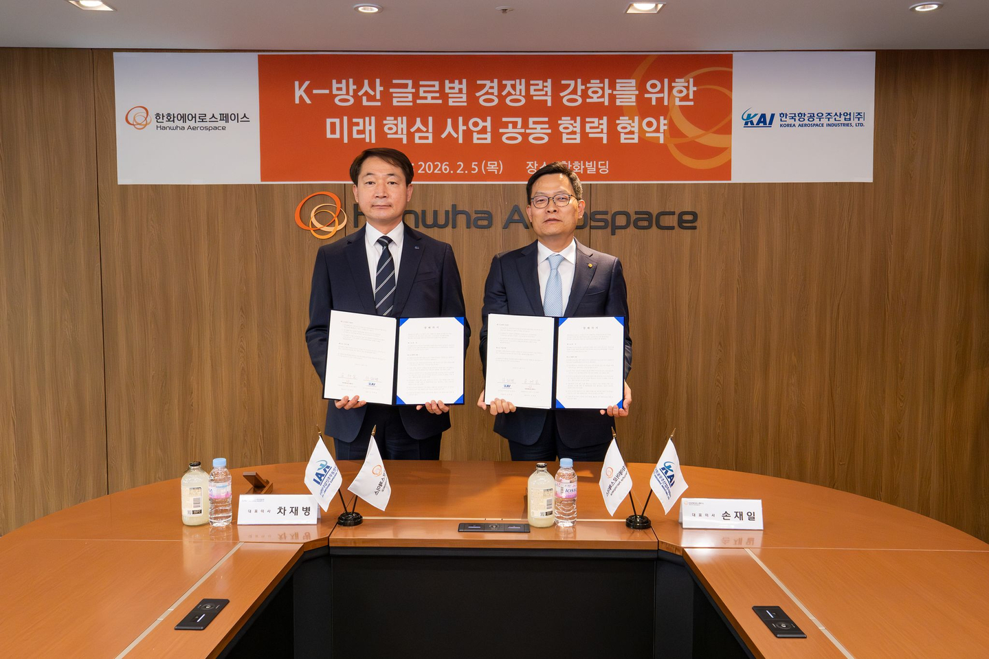 Cha Jae-byeong, CEO of Korea Aerospace Industries, left, and Son Jae-il, CEO of Hanwha Aerospace, pose for a photo after signing a memorandum of understanding for joint cooperation on future core projects to strengthen the global competitiveness of Korea’s defense industry on Feb. 5 at Hanwha Building in Jung District, central Seoul. [HANWHA AEROSPACE/KOREA AEROSPACE INDUSTRIES] 