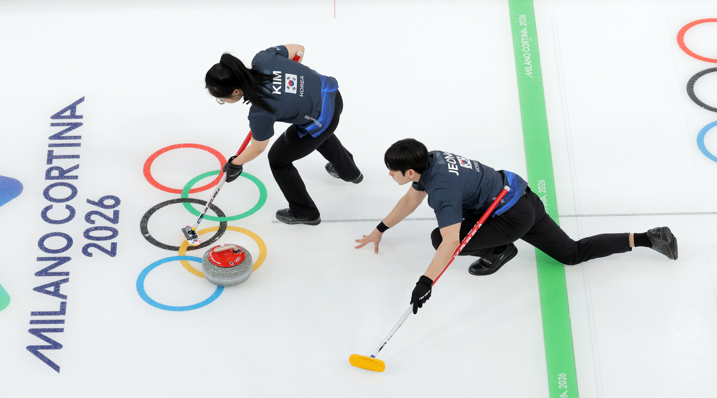 Kim Seon-yeong, top, and Jeong Yeong-seok of Korea compete in a round-robin match of the mixed doubles curling tournament at the 2026 Winter Olympics against Italy at Cortina Curling Olympic Stadium in Cortina d'Ampezzo, Italy, on Feb. 5. [YONHAP]