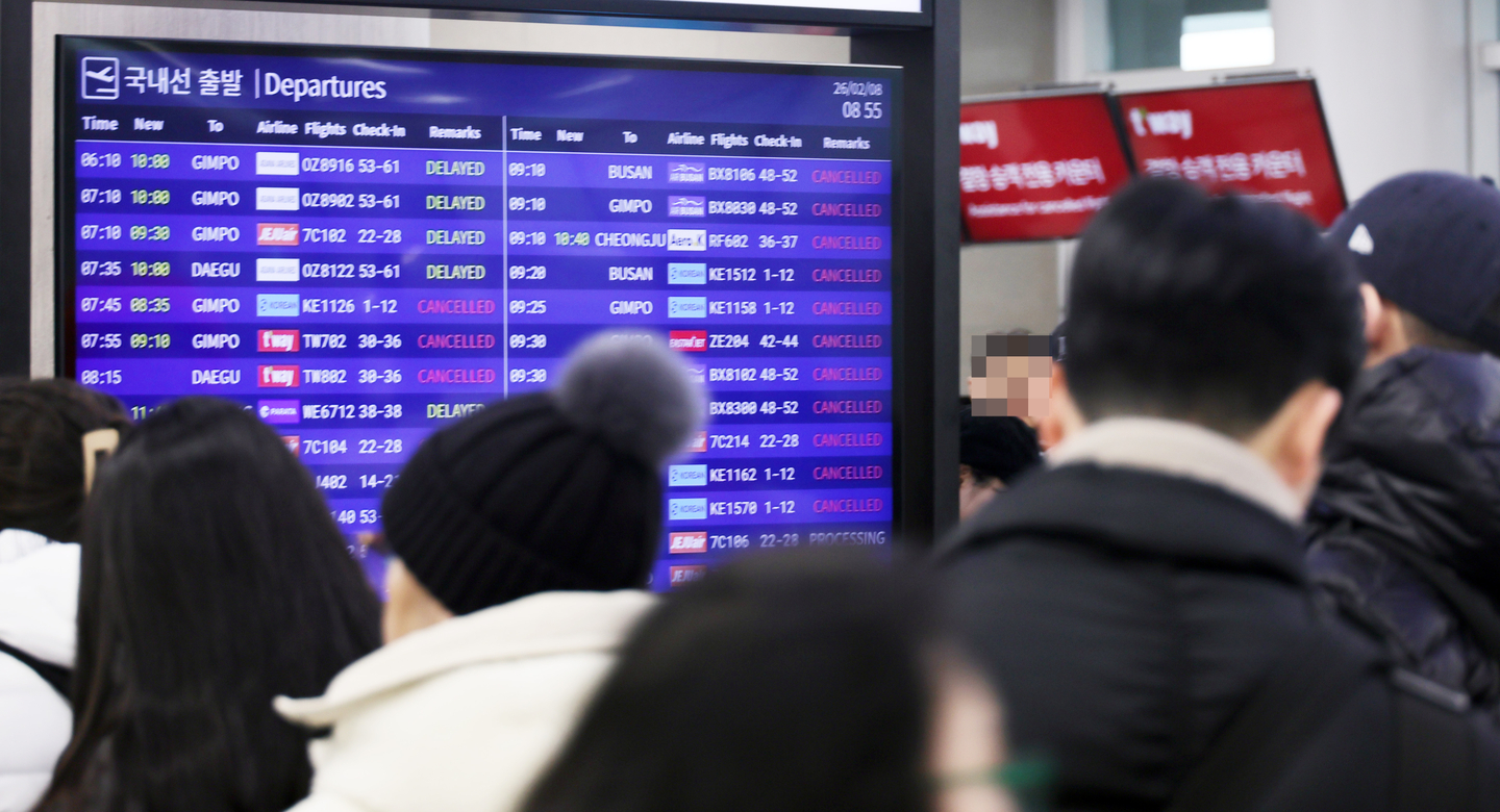 An electronic board shows cancellations and delays in flights at Jeju International Airport due to heavy snow on Feb. 8, 2026. [YONHAP]