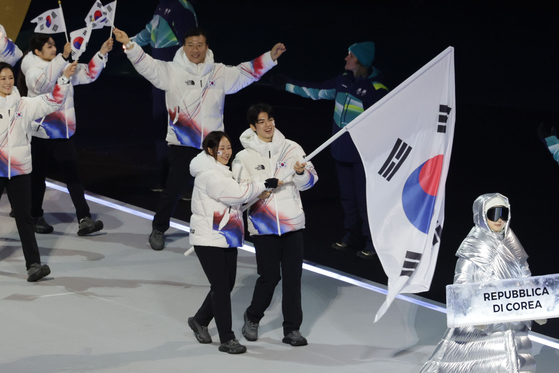 Team Korea enters the San Siro stadium in Milan at the opening ceremony of the 2026 Milan-Cortina Winter Olympics held Feb. 6, with figure skater Cha Jun-hwan and speed skater Park Ji-woo bearing the Korean national flag. [KIM JONG-HO]