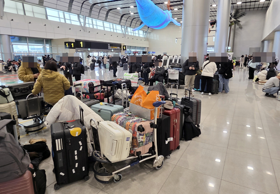 Passengers wait for the resumption of flights at Jeju International Airport on Feb. 8, 2026, as heavy snow grounded flights on Korea's southern island of Jeju. [YONHAP]