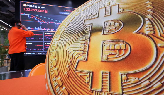 The prices of digital assets including the Bitcoin are displayed on a screen at Bithumb Lounge in Seocho District, southern Seoul, on Jan. 23. [NEWS1] 