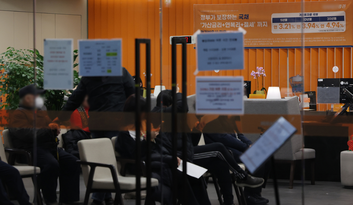 Customers wait in line for consultations at a brokerage firm branch in Seoul on Jan. 26. [YONHAP]