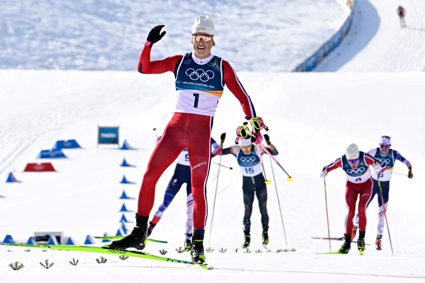 Norway's Johannes Hoesflot Klaebo, center, celebrates as he crosses the finish line during the men's cross country 10-kilometer skiathlon event of the Milan-Cortina 2026 Winter Olympic Games at Tesero Cross-Country Skiing Stadium in Lago di Tesero (Val di Fiemme), on Feb. 8. [AFP/YONHAP]
