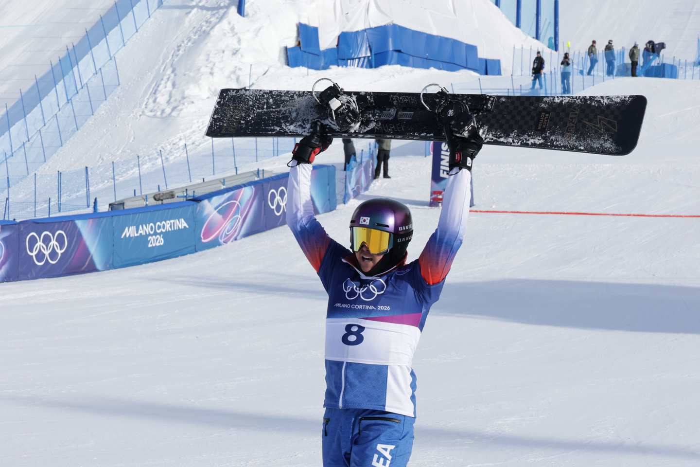 Kim Sang-kyum lifts his snowboard into the air after he finishes his performance during the snowboard men's parallel giant slalom quarter final at Livigno Snow Park during the Milan Cortina 2026 Winter Olympic Games, in Livigno, on Feb. 8. [KIM JONG-HO]