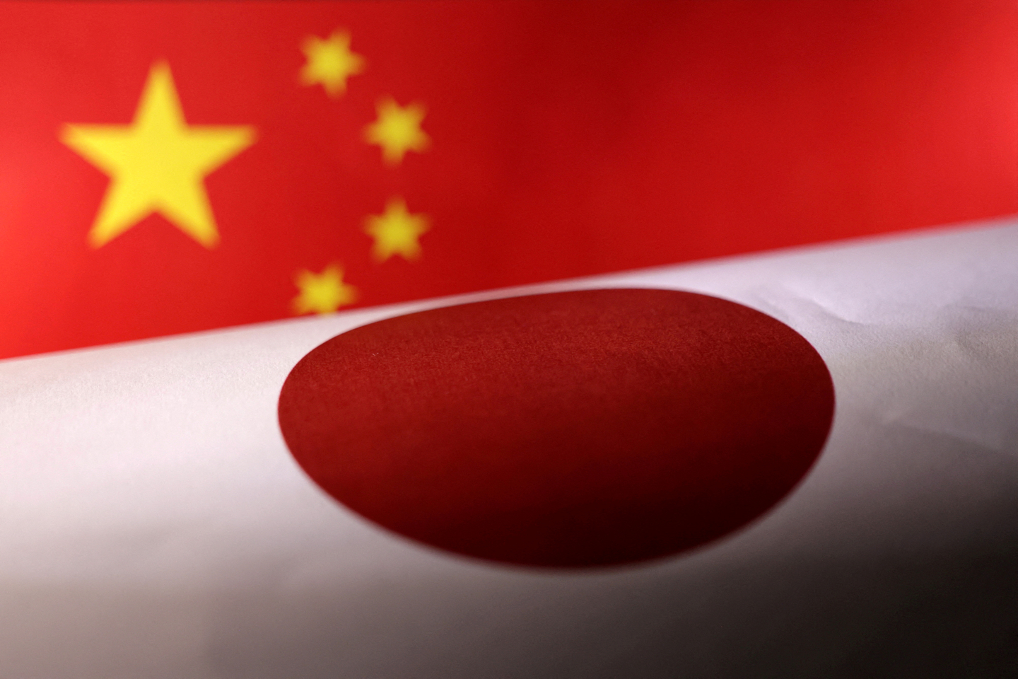 Printed Chinese and Japanese flags are seen in this illustration created on July 21, 2022. [REUTERS/YONHAP]