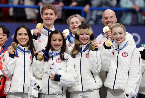 Gold medallist's Ilia Malinin, Amber Glenn, Ellie Kam, Danny O'Shea, Madison Chock, Evan Bates and Alysa Liu of United States celebrate on the podium after winning the Team Event at the Milano Ice Skating Arena in Milan, Italy on Feb. 8. [REUTERS/YONHAP]