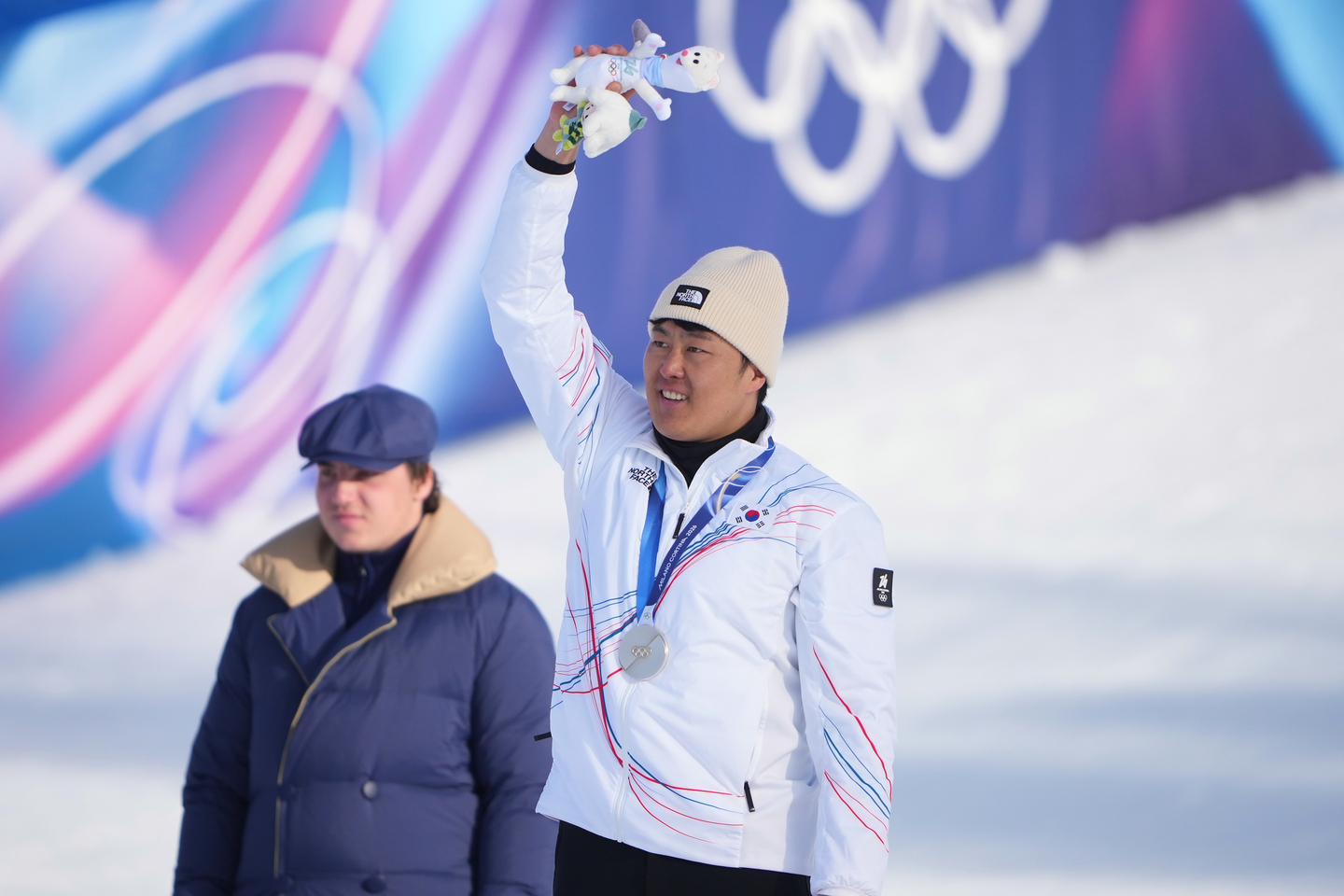 Silver medalist Kim Sang-kyum, center, celebrates after the men's snowboarding parallel giant slalom finals at the 2026 Winter Olympics, in Livigno, Italy, Feb. 8. [AP/YONHAP]
