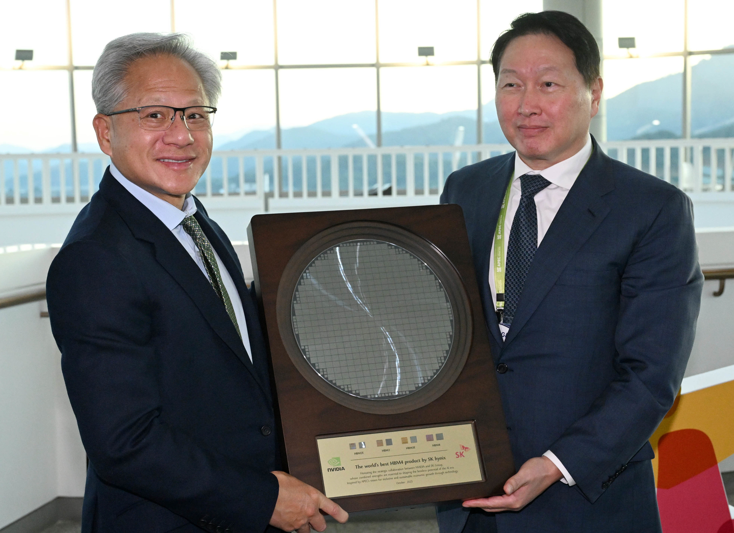 Nvidia CEO Jensen Huang receives an SK hynix HBM4 semiconductor wafer as a gift from SK Group Chairman and Korea Chamber of Commerce and Industry Chairman Chey Tae-won at the APEC CEO Summit held at the Gyeongju Arts Center in Gyeongju, North Gyeongsang, on Oct. 31. [JOINT PRESS CORPS]
