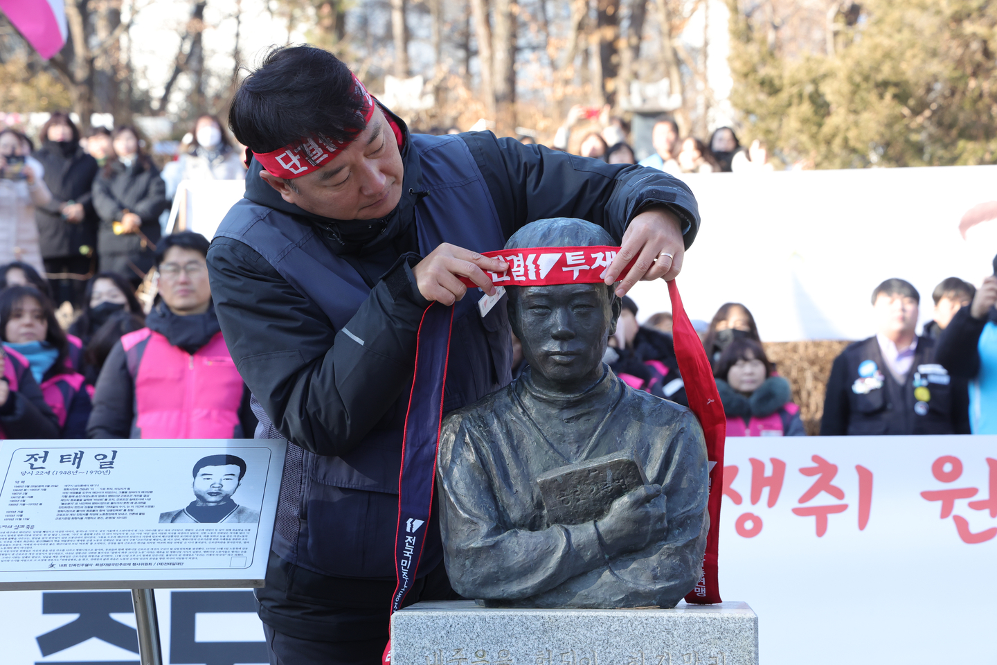 Korean Confederation of Trade Unions chief Yang Kyung-soo is seen draping a bandana with printed slogans onto a bust of Jeon Tae-il, a workers' rights activist, during a New Year's kickoff ceremony of the union in Namyangju, Gyeonggi, on Jan. 5. [YONHAP]