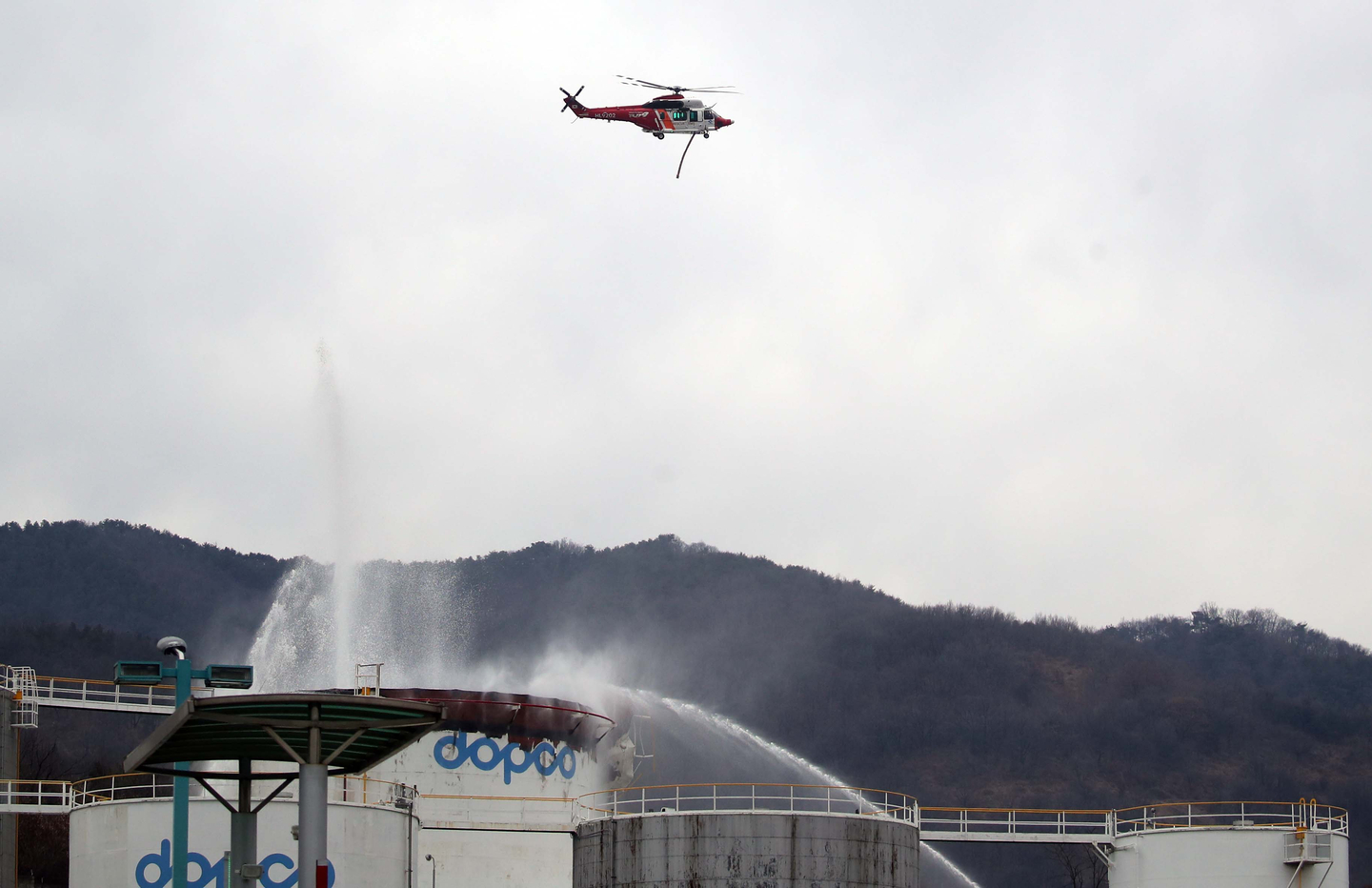 A helicopter is seen above the scene of a fire that broke out at a Daehan Oil Pipeline Corporation facility in Gyeongsan, North Gyeongsang, on Feb. 10. [YONHAP]
