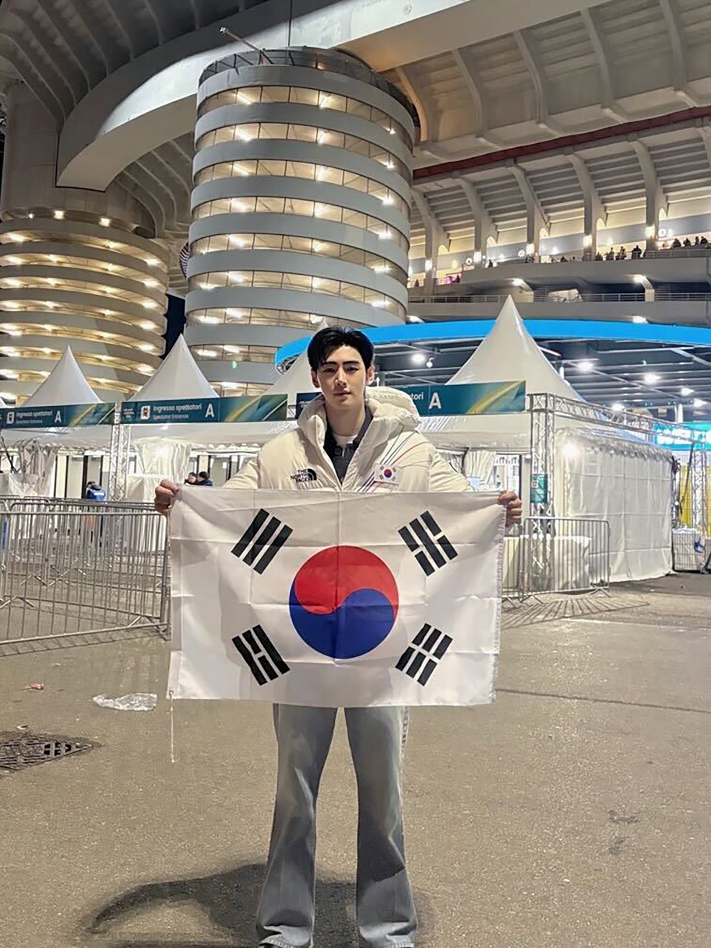 Enhypen's Sunghoon holds up a Korean flag at the Milan-Cortina Winter Olympics in Italy. [BELIFT LAB]