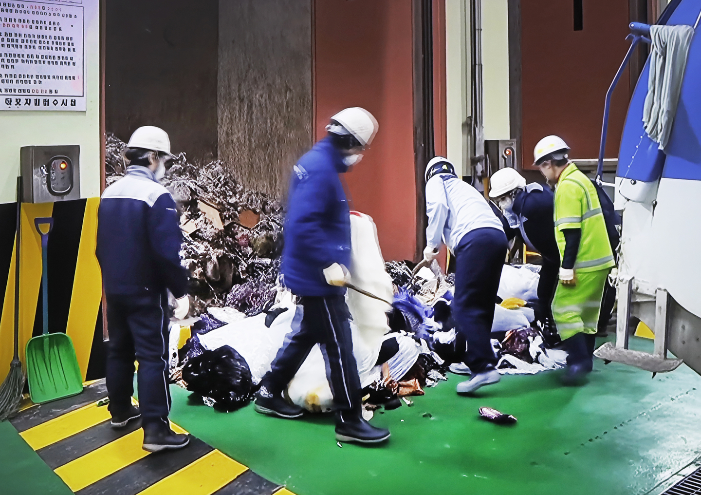 Resident monitors randomly check waste at the bunkers of the Mapo Resource Recovery Plant in western Seoul, in an undated video shown at the facility. [PARK SANG-MOON]
