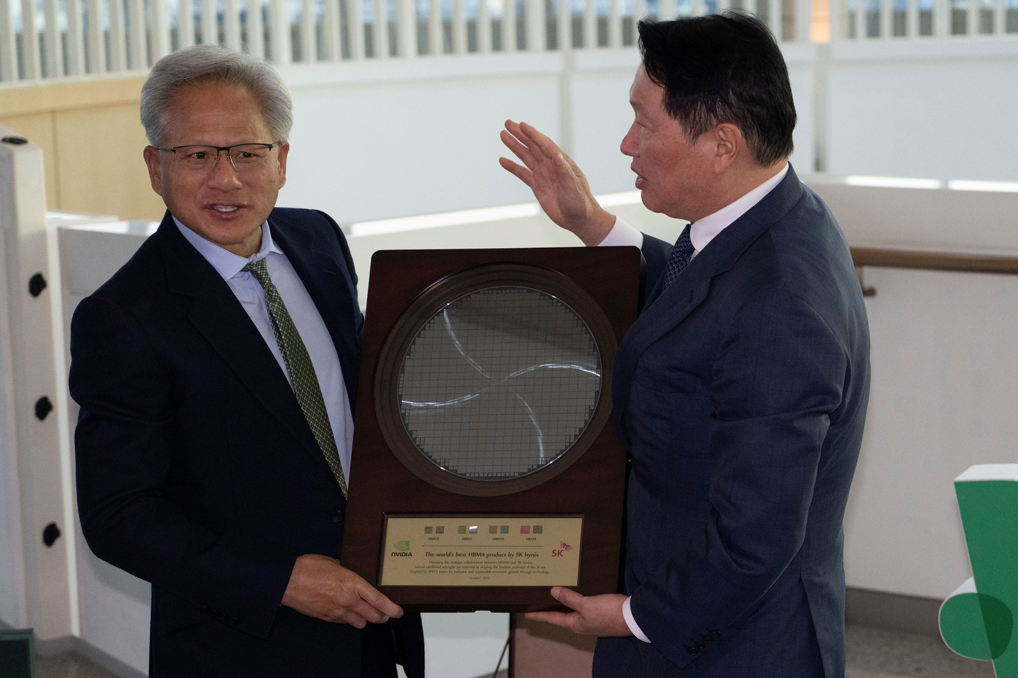 Nvidia CEO Jensen Huang, left, is presented a silicon wafer by SK Group Chairman Chey Tae-won, during the APEC CEO Summit in Gyeongju, Korea, on Oct. 31, 2025.  [AP/YONHAP]