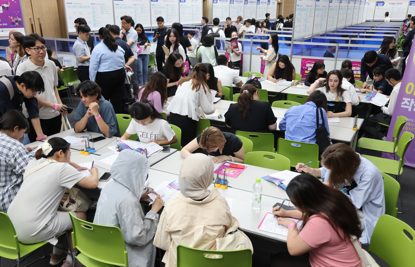 International students work on their resumes at the Job Fair for International Students in Busan on Aug. 19, 2025, at the Bexco convention center. Busan Metropolitan City has launched a new support center dubbed the Study Busan Hub to provide consultation services and practical assistance for international students in the region. [YONHAP]