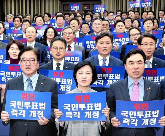 Liberal lawmakers hold placards calling for amendment of the Referendum Act during a general assembly at the National Assembly in western Seoul on April 9, 2018. [JOONGANG ILBO]