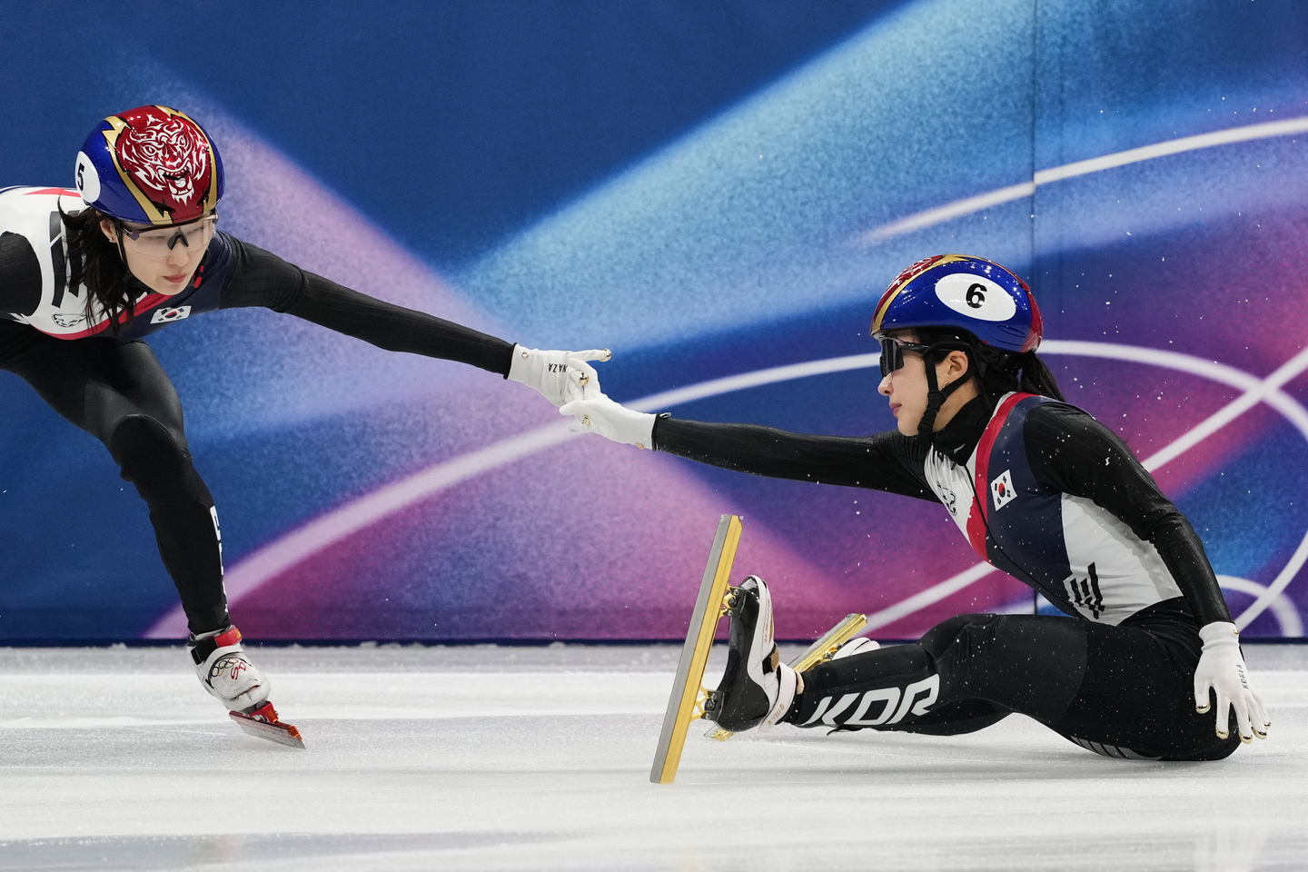 Choi Min-jeong, left, and Kim Gil-li tag after a crash in the semifinals of the team mixed relay short track speed skating race at the 2026 Milan-Cortina Winter Olympics in Milan on Feb. 10. [AP/YONHAP] 