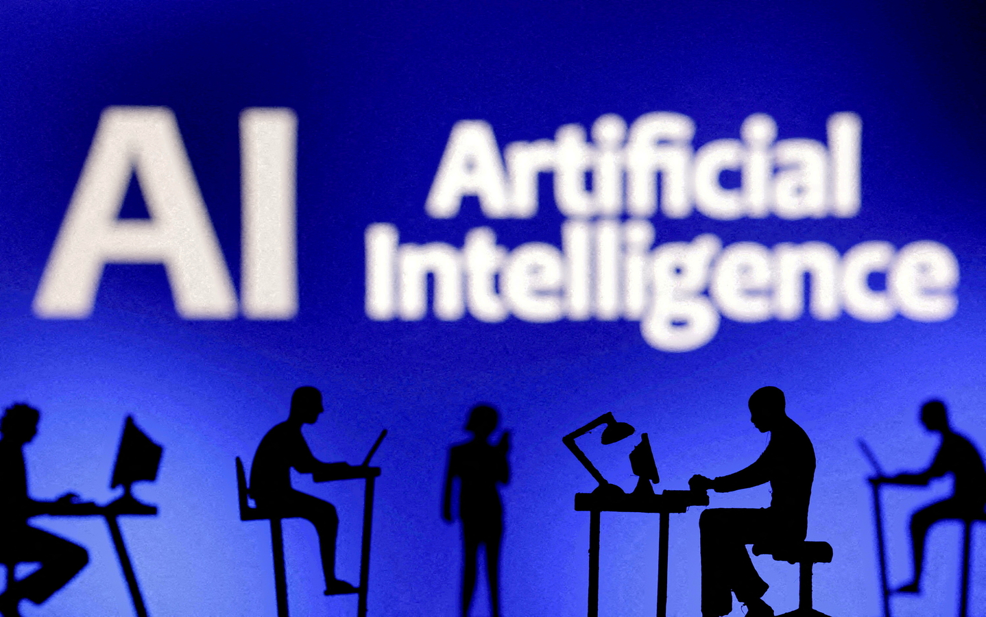 Figurines with computers and smartphones are seen in front of the words ″Artificial Intelligence″ in this file photo from Feb. 19, 2024.  [REUTERS/YONHAP] 