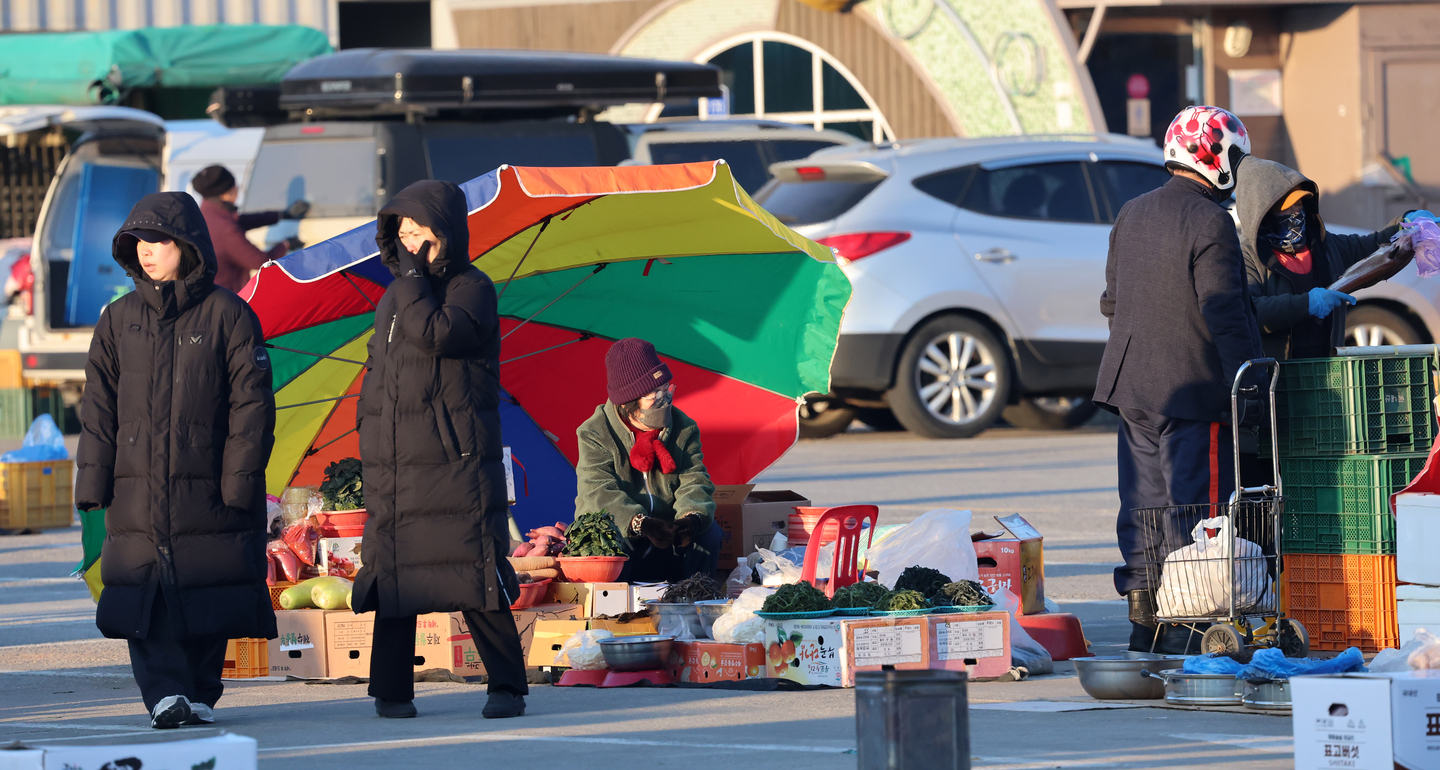 A vendor waits for customers at an early-morning farm produce market along the Namdae Stream in Gangneung, Gangwon, on Feb. 8. [YONHAP]