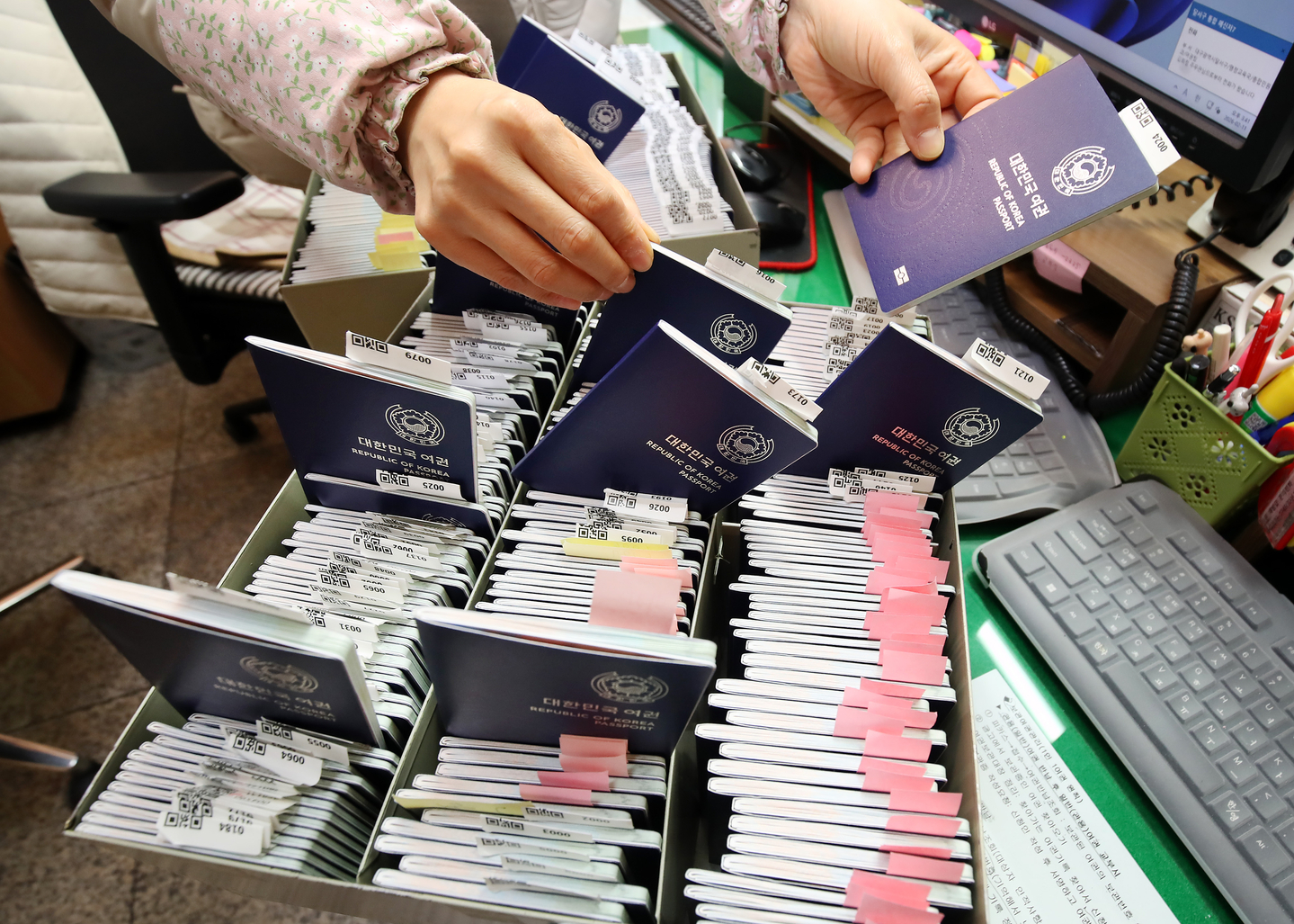 Passport applications are on the rise ahead of the Lunar New Year holiday which starts on Feb.14. On the afternoon of Feb.11, an official organizes newly issued passports at the passport service desk in the civil affairs office of Dalseo District Office in Daegu. [NEWS1]