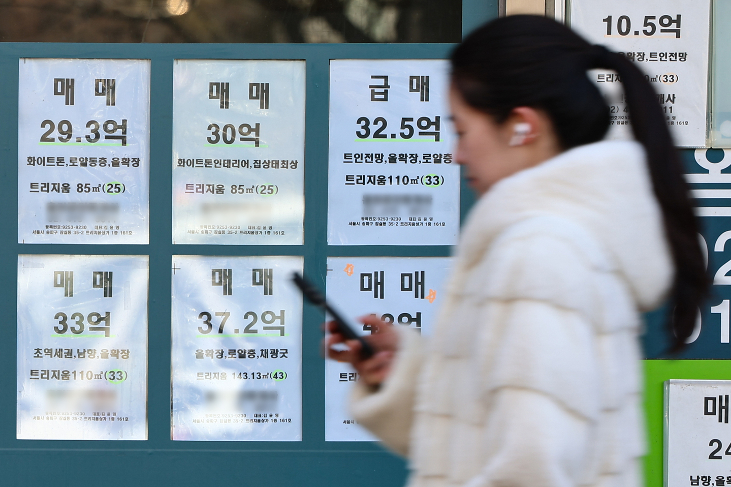 A pedestrian walks past a real estate agency displaying housing listings in Gangnam District, southern Seoul, on Feb. 8. [NEWS1]