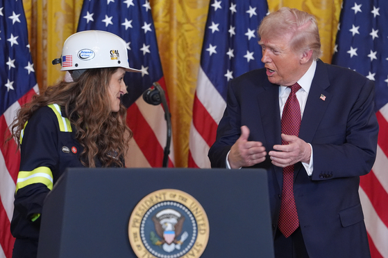 President Donald Trump talks with Kayla Blackford, a heavy equipment operator at Bear Run Mine near Carlisle, Indiana, during an event on coal power in the East Room of the White House, Wednesday, Feb. 11, 2026, in Washington. [AP/YONHAP]