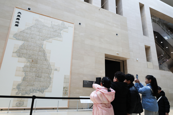 Children take photo of the newly installed life-size copy of the Daedongyeojido at the Path to History hallway on the first floor of the museum on Feb. 12. The Daedongyeojido, also known as the Map of the Great East, is Korea's first large-scale map created by cartographer Kim Jeong-ho in the 19th century and is listed as Korea's National Treasure No. 850. Measuring 6.7 meters (nearly 22 feet) in length and 3.8 meters in width, the map divides the Korean Peninsula into 22 sections, each compiled into a separate booklet, making it difficult to display in its entirety. [YONHAP]
