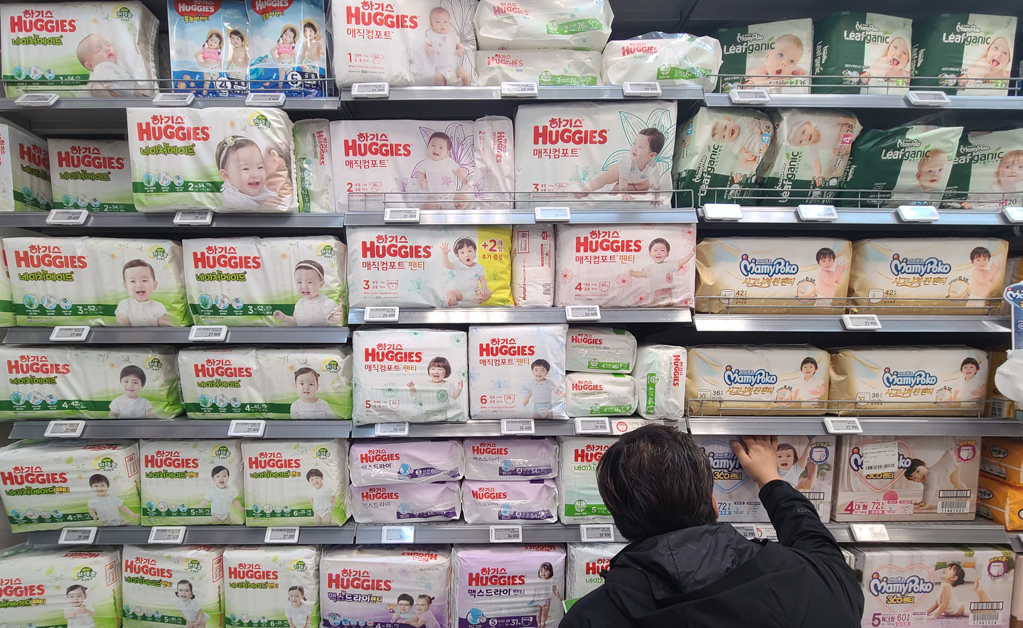 A consumer looks through diaper products at a supermarket in Seoul on Oct. 27, 2021. [YONHAP]