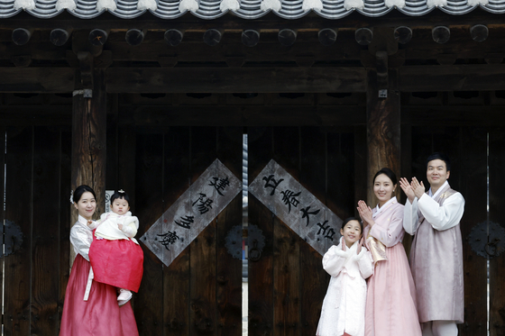 A family poses in front of the Namsangol Hanok Village in Jung District, central Seoul, in celebration of spring on Feb. 4. [NEWS1]