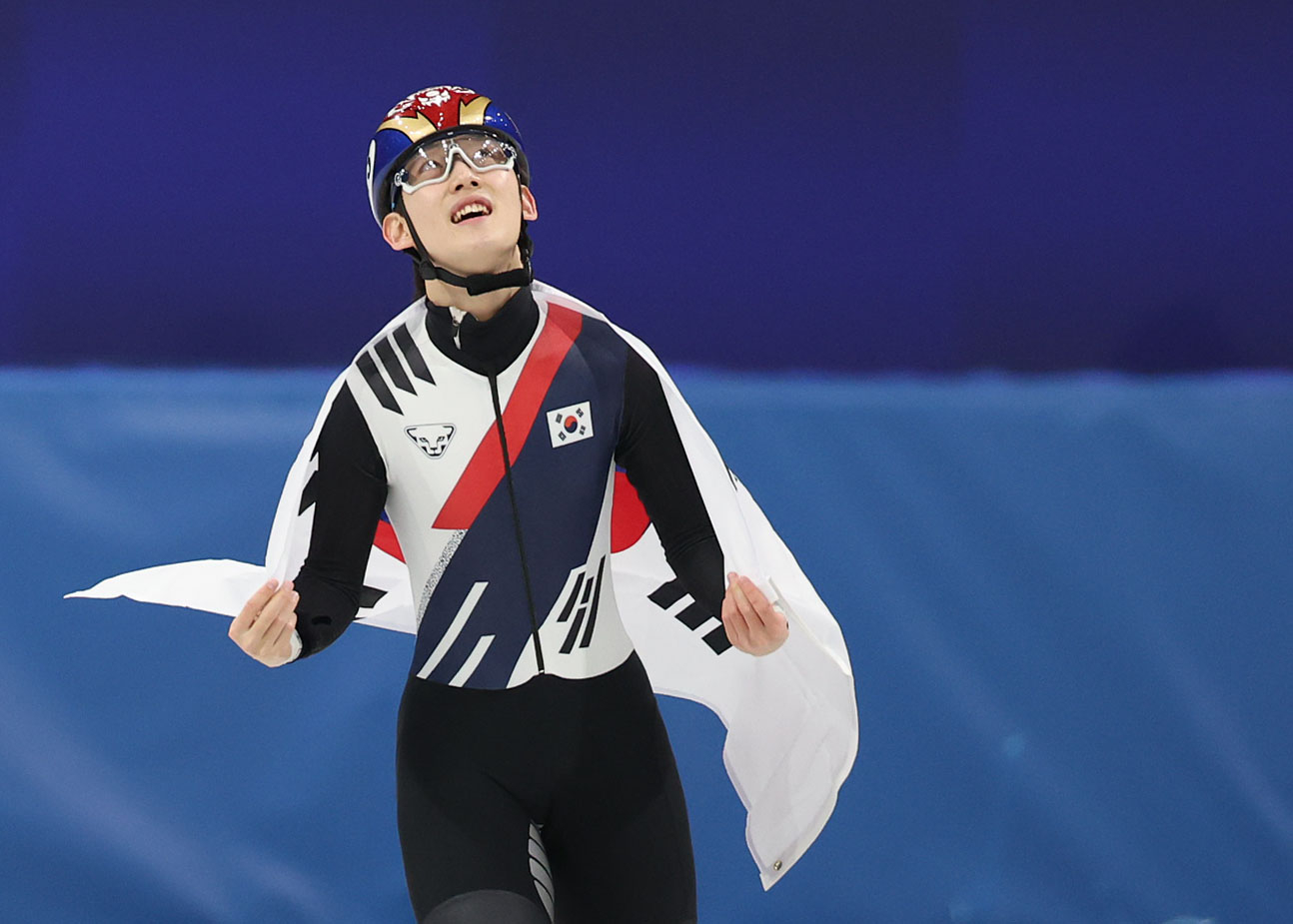 Rim Jong-un of Korea celebrates with the Taegeukgi, the Korean national flag, draped over his shoulders after winning the bronze medal in the men’s 1,000-meter short-track speed skating final at the 2026 Milan-Cortina Winter Olympics on Feb. 12. [YONHAP]