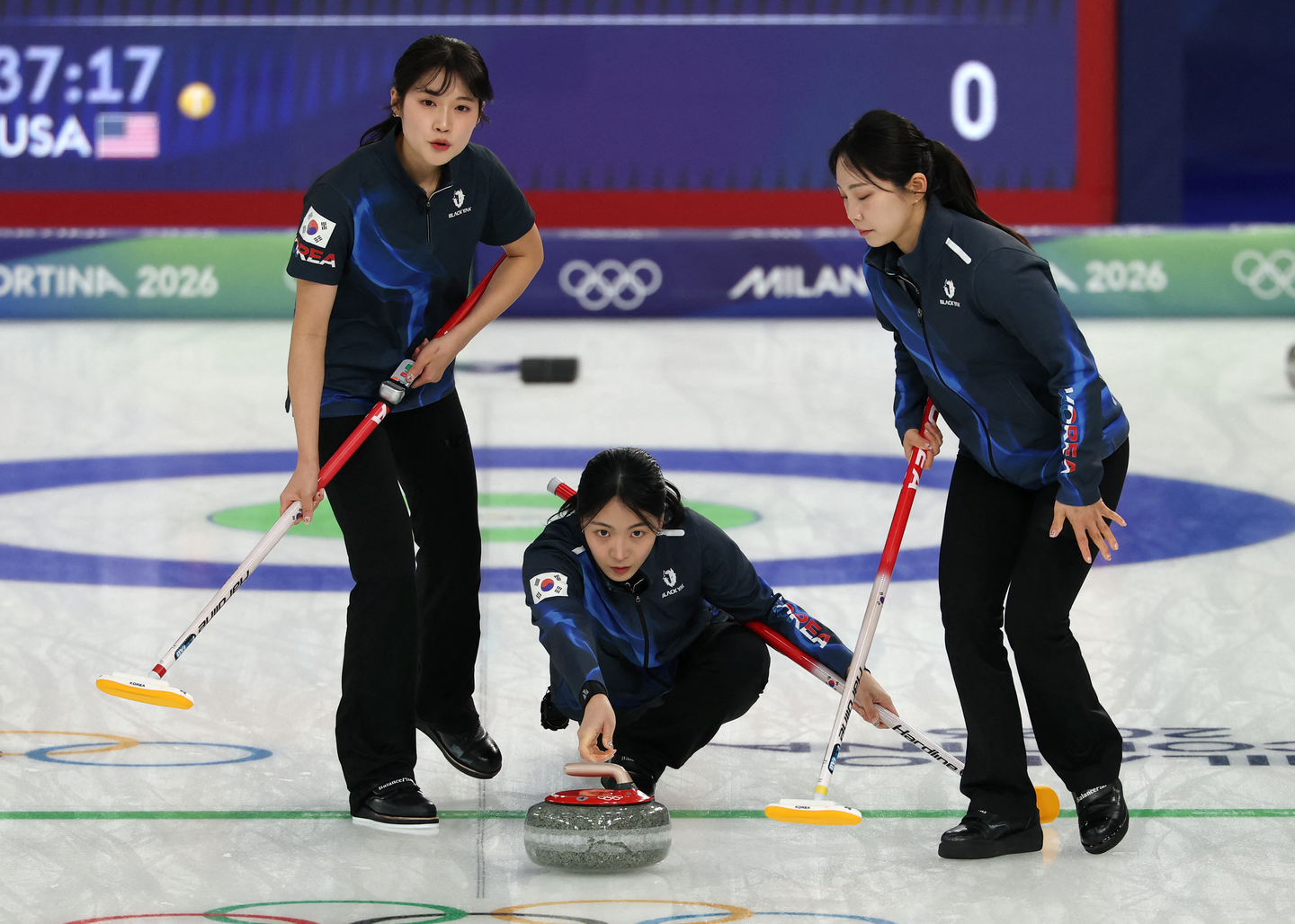 Kim Min-ji of Korea, center, throws the stone while flanked by teammates Seol Ye-eun, left, and Kim Su-ji during the team's round-robin match against the United States in the women's curling tournament at the Winter Olympics at Cortina Curling Olympic Stadium in Cortina d'Ampezzo, Italy, on Feb. 12.  [REUTERS/YONHAP]